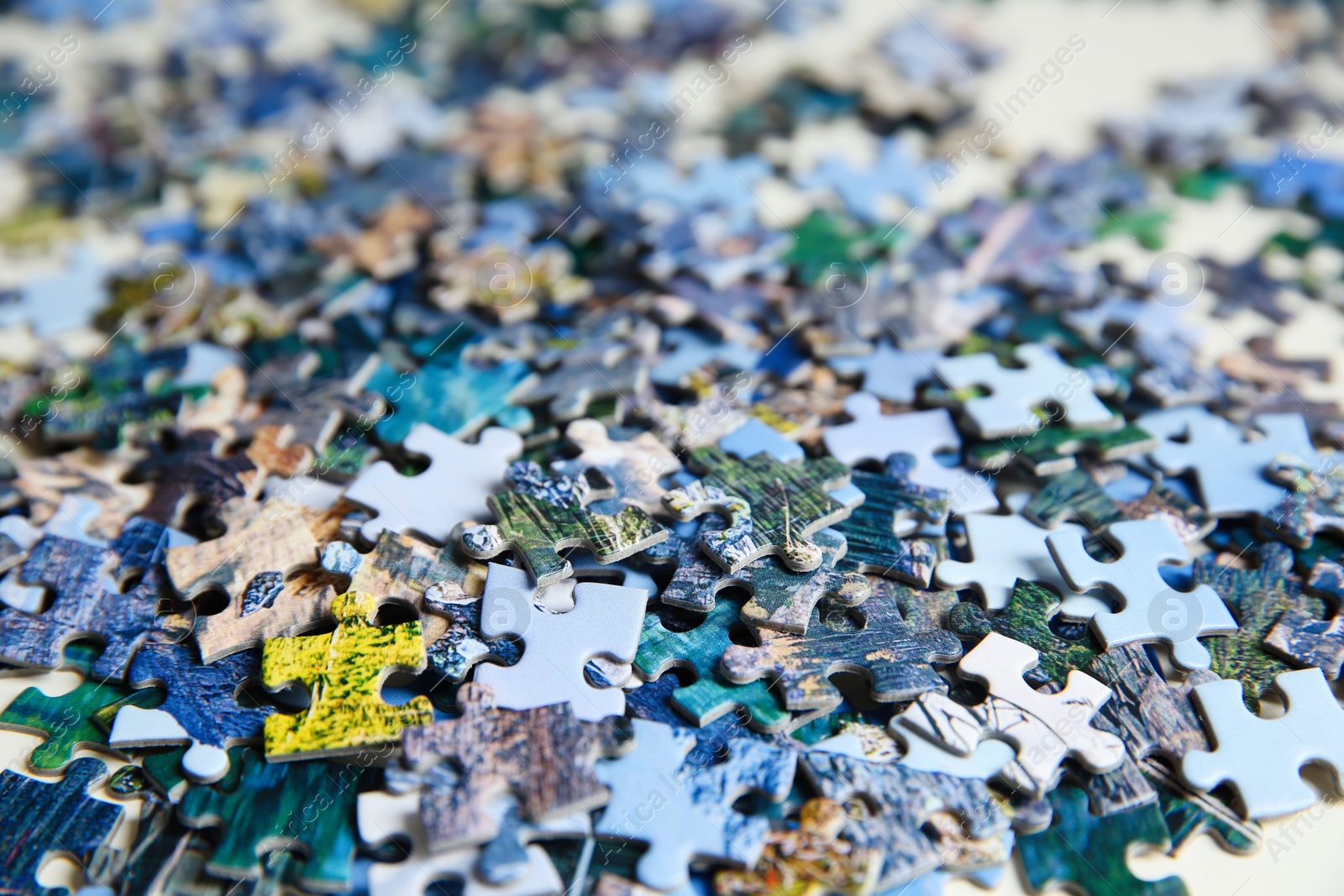 Jigsaw puzzle pieces on table, closeup view Photo of Jigsaw puzzle pieces on table, closeup view