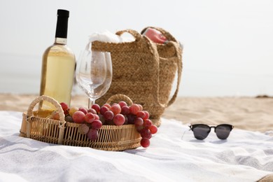 Bag, blanket, wine and other stuff for beach picnic on sandy seashore Photo of Bag, blanket, wine and other stuff for beach picnic on sandy seashore