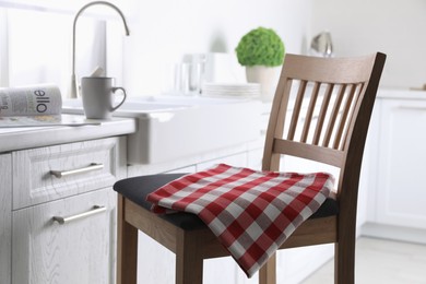 Dry towel on wooden chair in kitchen Photo of Dry towel on wooden chair in kitchen