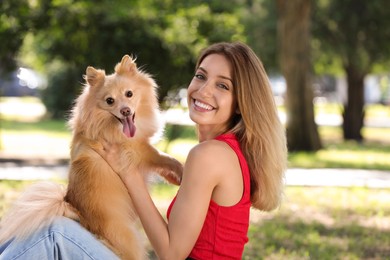 Young woman with her cute dog in park on sunny day Photo of Young woman with her cute dog in park on sunny day