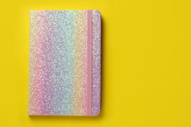 New stylish planner with hard cover on yellow background, top view. Space for text Photo of New stylish planner with hard cover on yellow background, top view. Space for text
