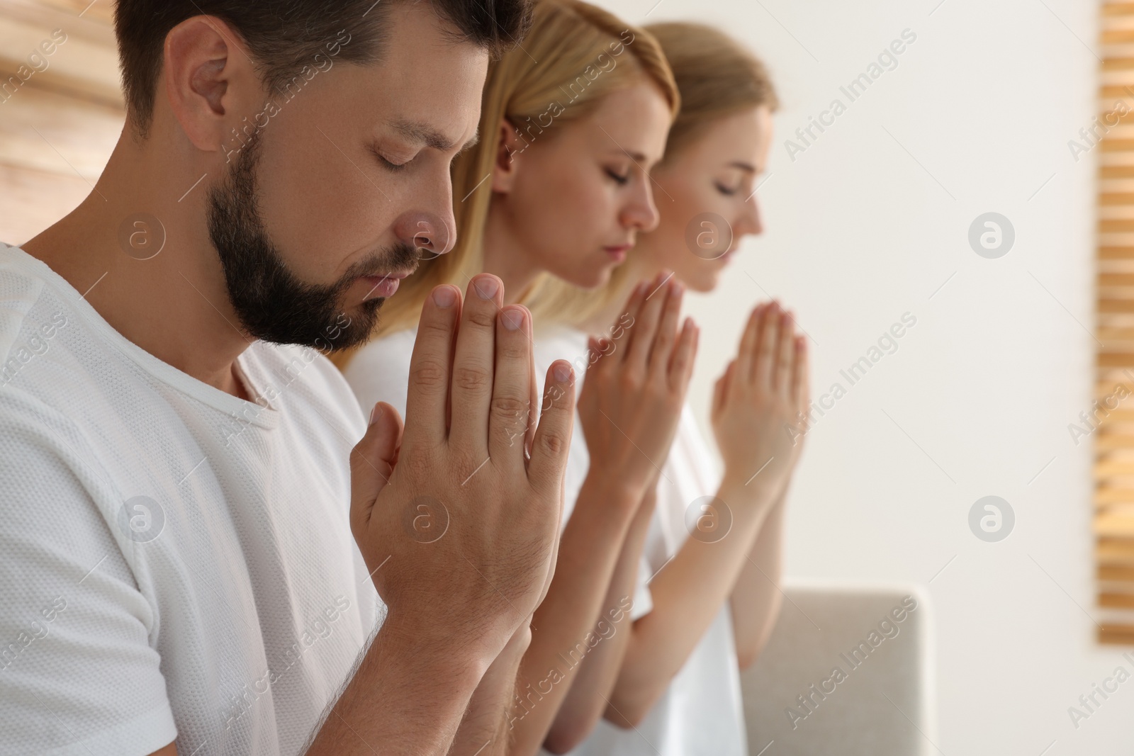Group of religious people praying together indoors. Space for text Photo of Group of religious people praying together indoors. Space for text