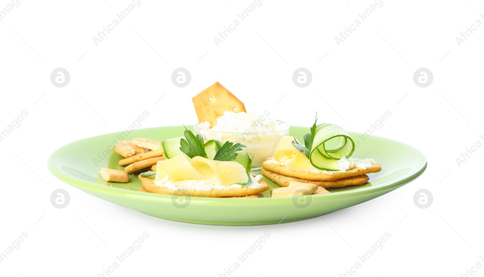 Delicious crackers with cream cheese, cucumber and parsley on white background Photo of Delicious crackers with cream cheese, cucumber and parsley on white background