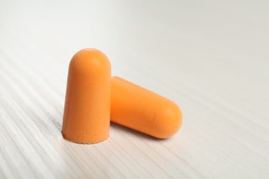 Pair of ear plugs on white wooden background, closeup Photo of Pair of ear plugs on white wooden background, closeup
