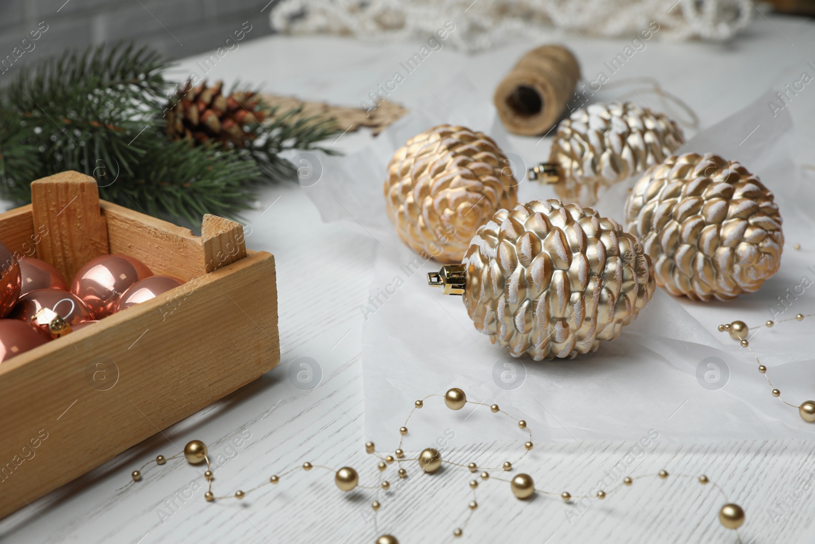 Composition with beautiful Christmas baubles on white wooden table Photo of Composition with beautiful Christmas baubles on white wooden table