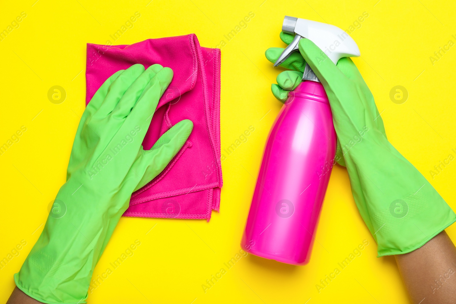 Woman in green rubber gloves with microfiber cloth and detergent on yellow background, top view Photo of Woman in green rubber gloves with microfiber cloth and detergent on yellow background, top view
