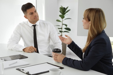 Office employees talking at table during meeting Photo of Office employees talking at table during meeting