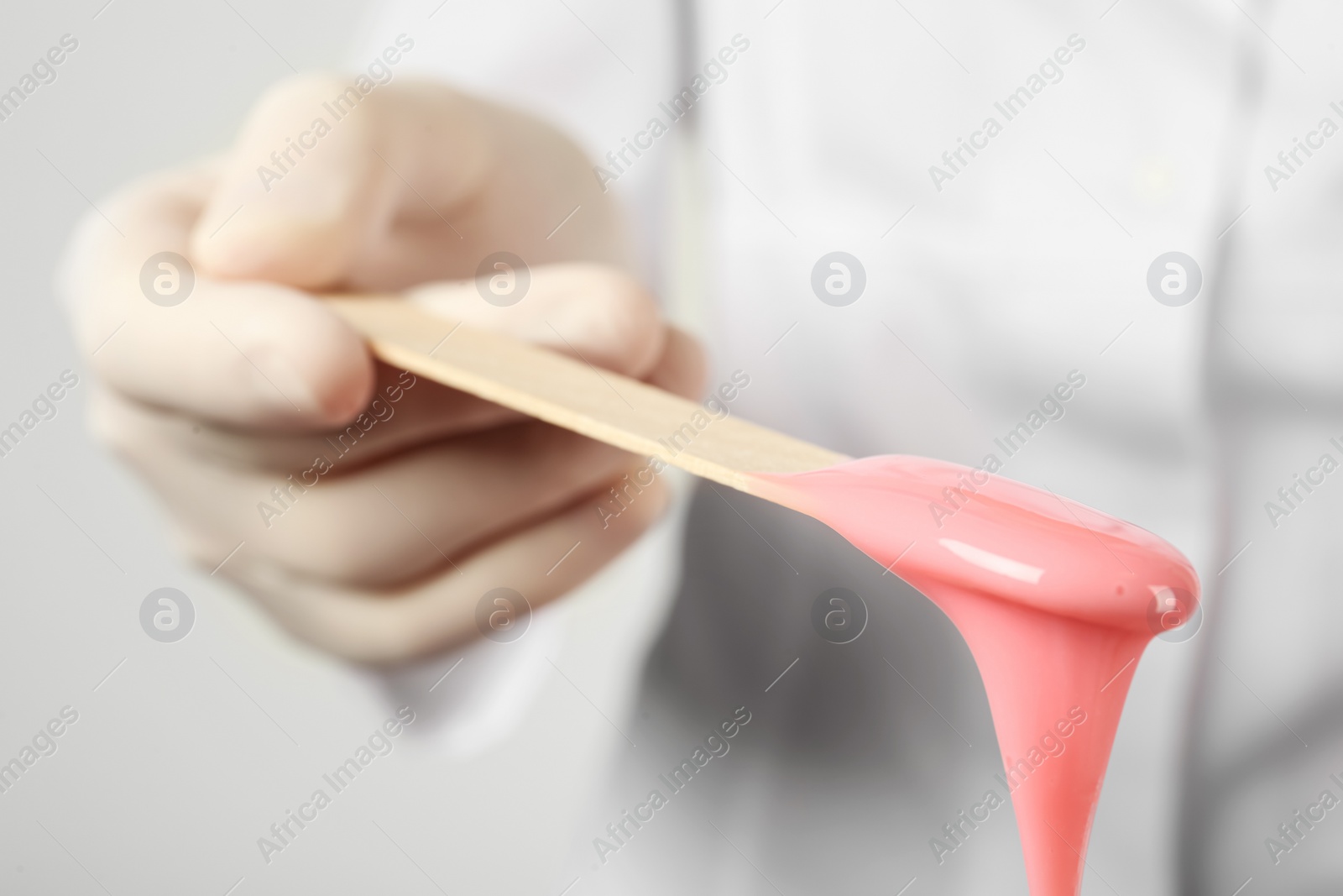 Woman holding spatula with hot depilatory wax, closeup Photo of Woman holding spatula with hot depilatory wax, closeup