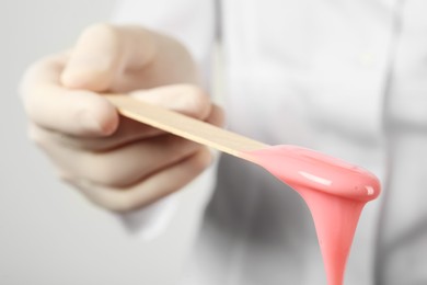 Woman holding spatula with hot depilatory wax, closeup Photo of Woman holding spatula with hot depilatory wax, closeup