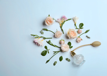 Photo of Beautiful composition with bottle of perfume and flowers on white background, flat lay. Space for text