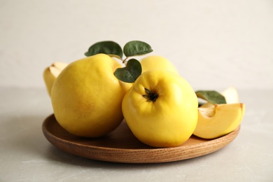 Fresh ripe organic quinces with leaves on light table Photo of Fresh ripe organic quinces with leaves on light table