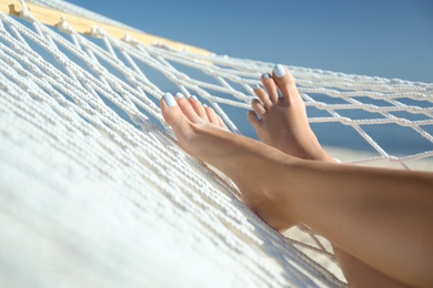 Young woman relaxing in hammock on beach, closeup Photo of Young woman relaxing in hammock on beach, closeup