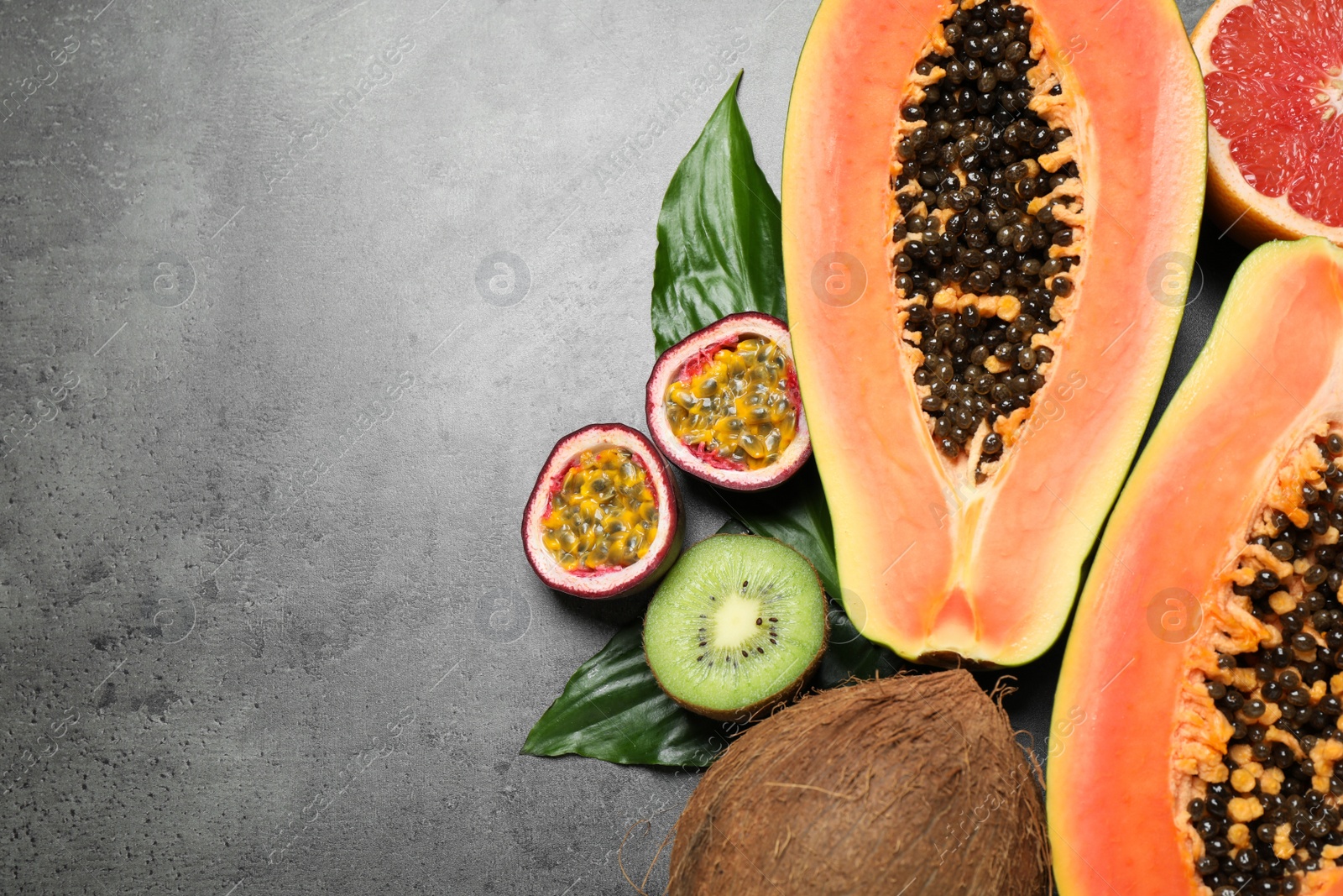 Fresh ripe papaya and other fruits on grey table, flat lay. Space for text Photo of Fresh ripe papaya and other fruits on grey table, flat lay. Space for text