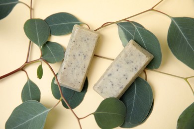 Soap bars and green leaves on beige background, flat lay. Eco friendly personal care product Photo of Soap bars and green leaves on beige background, flat lay. Eco friendly personal care product