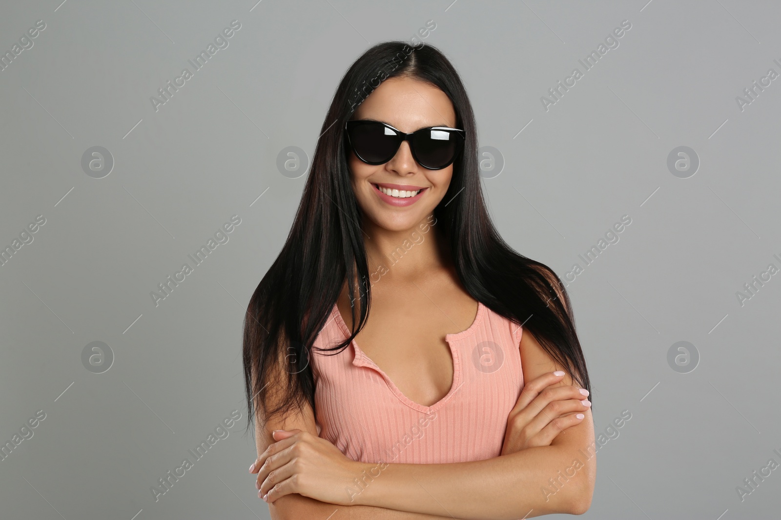 Beautiful woman wearing sunglasses on grey background Photo of Beautiful woman wearing sunglasses on grey background