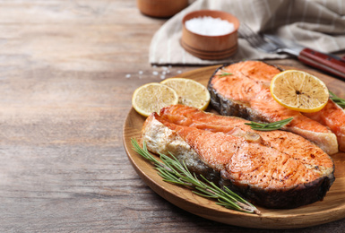 Tasty cooked red fish on wooden table Photo of Tasty cooked red fish on wooden table