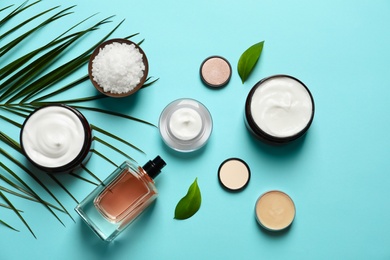 Different skin care cosmetic products with green leaves on color background, top view Photo of Different skin care cosmetic products with green leaves on color background, top view