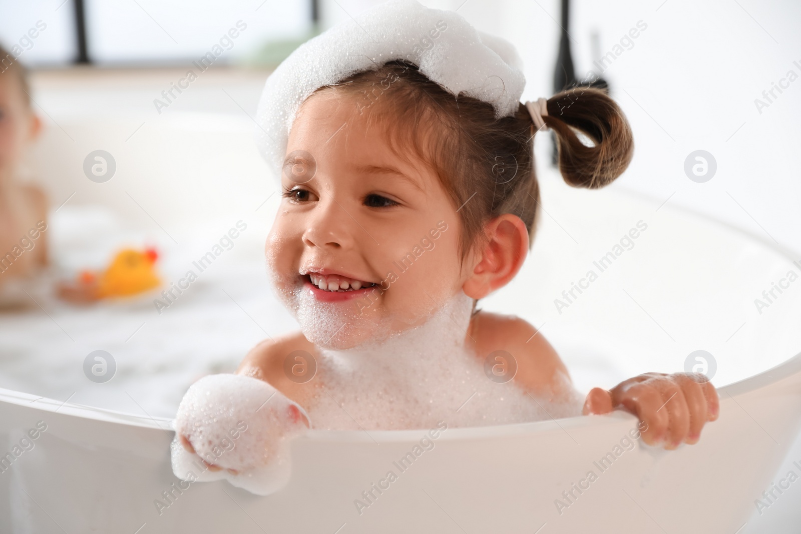 Cute little girl taking bubble bath at home Photo of Cute little girl taking bubble bath at home