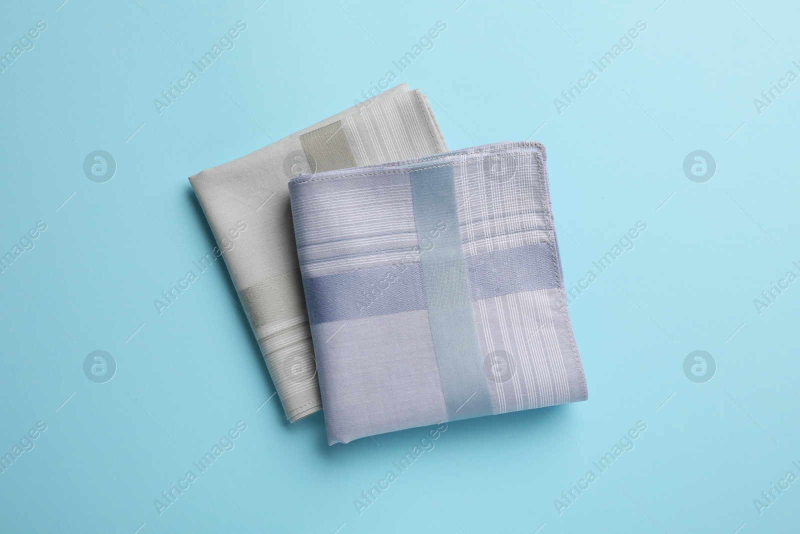 Stylish handkerchiefs on light blue background, flat lay Photo of Stylish handkerchiefs on light blue background, flat lay