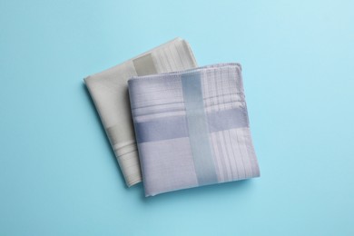 Stylish handkerchiefs on light blue background, flat lay Photo of Stylish handkerchiefs on light blue background, flat lay