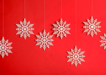 Beautiful decorative snowflakes hanging on red background Photo of Beautiful decorative snowflakes hanging on red background
