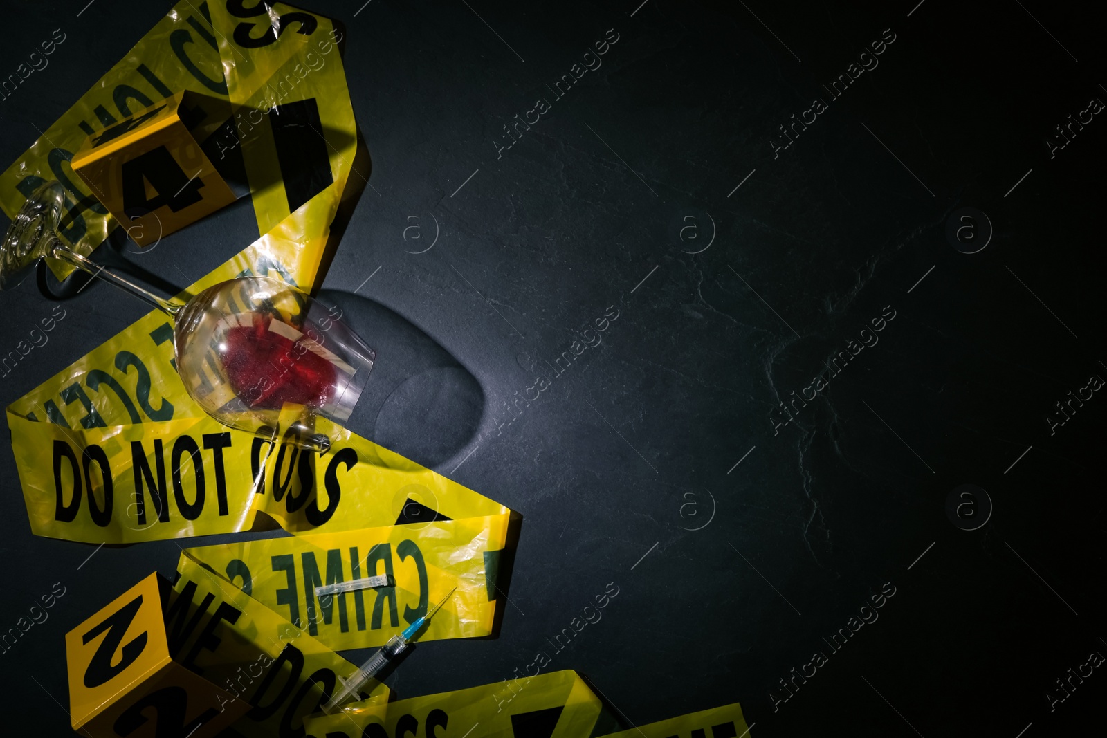 Flat lay composition with evidences and crime scene tape on black slate background, space for text Photo of Flat lay composition with evidences and crime scene tape on black slate background, space for text