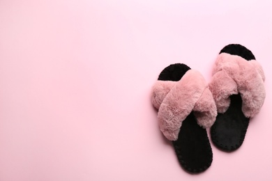 Pair of soft slippers on light pink background, flat lay. Space for text Photo of Pair of soft slippers on light pink background, flat lay. Space for text