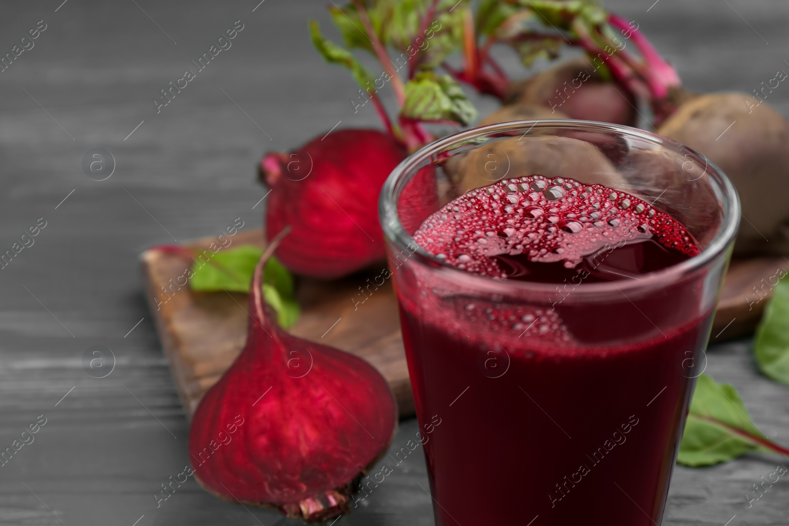 Fresh beet juice and raw vegetable on table, closeup Photo of Fresh beet juice and raw vegetable on table, closeup
