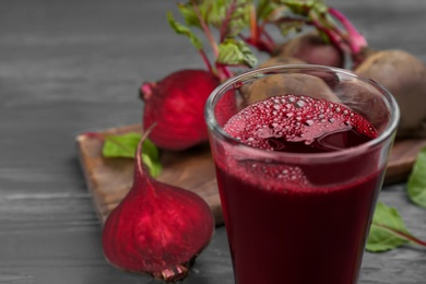Fresh beet juice and raw vegetable on table, closeup Photo of Fresh beet juice and raw vegetable on table, closeup