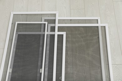 Set of window screens on wooden floor, above view Photo of Set of window screens on wooden floor, above view
