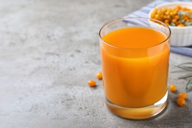 Delicious sea buckthorn juice on grey table. Space for text Photo of Delicious sea buckthorn juice on grey table. Space for text