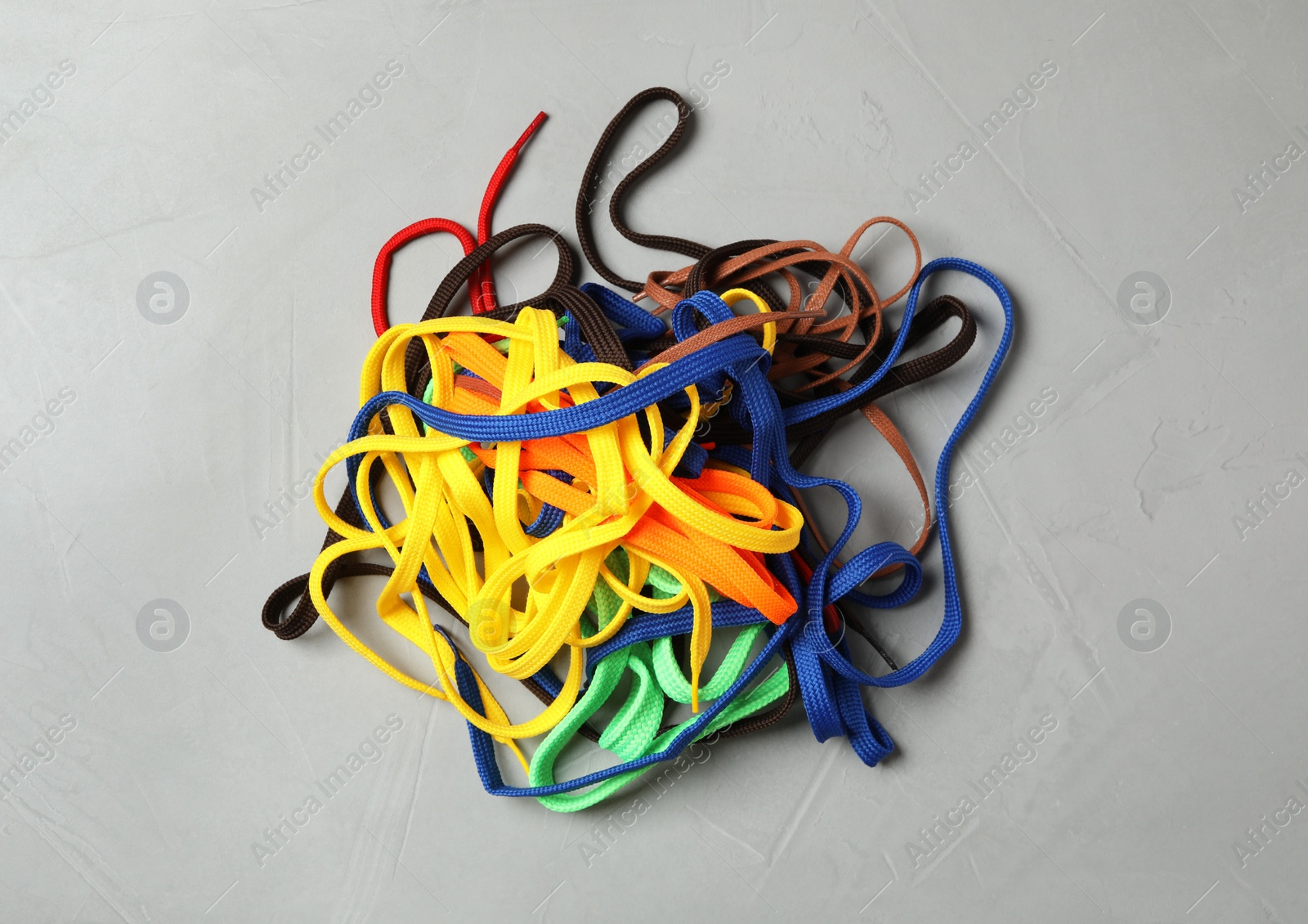 Pile of shoelaces on light grey stone background, flat lay Photo of Pile of shoelaces on light grey stone background, flat lay
