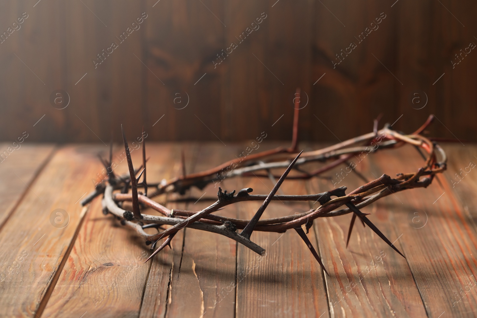 Photo of Crown of thorns on wooden table, space for text. Easter attribute