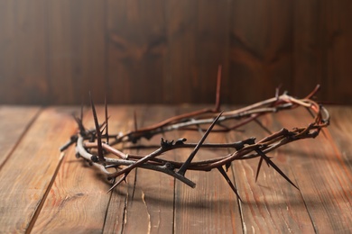 Crown of thorns on wooden table, space for text. Easter attribute Photo of Crown of thorns on wooden table, space for text. Easter attribute