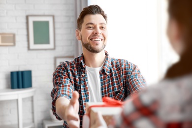 Photo of Man receiving gift for Father's Day from his daughter at home
