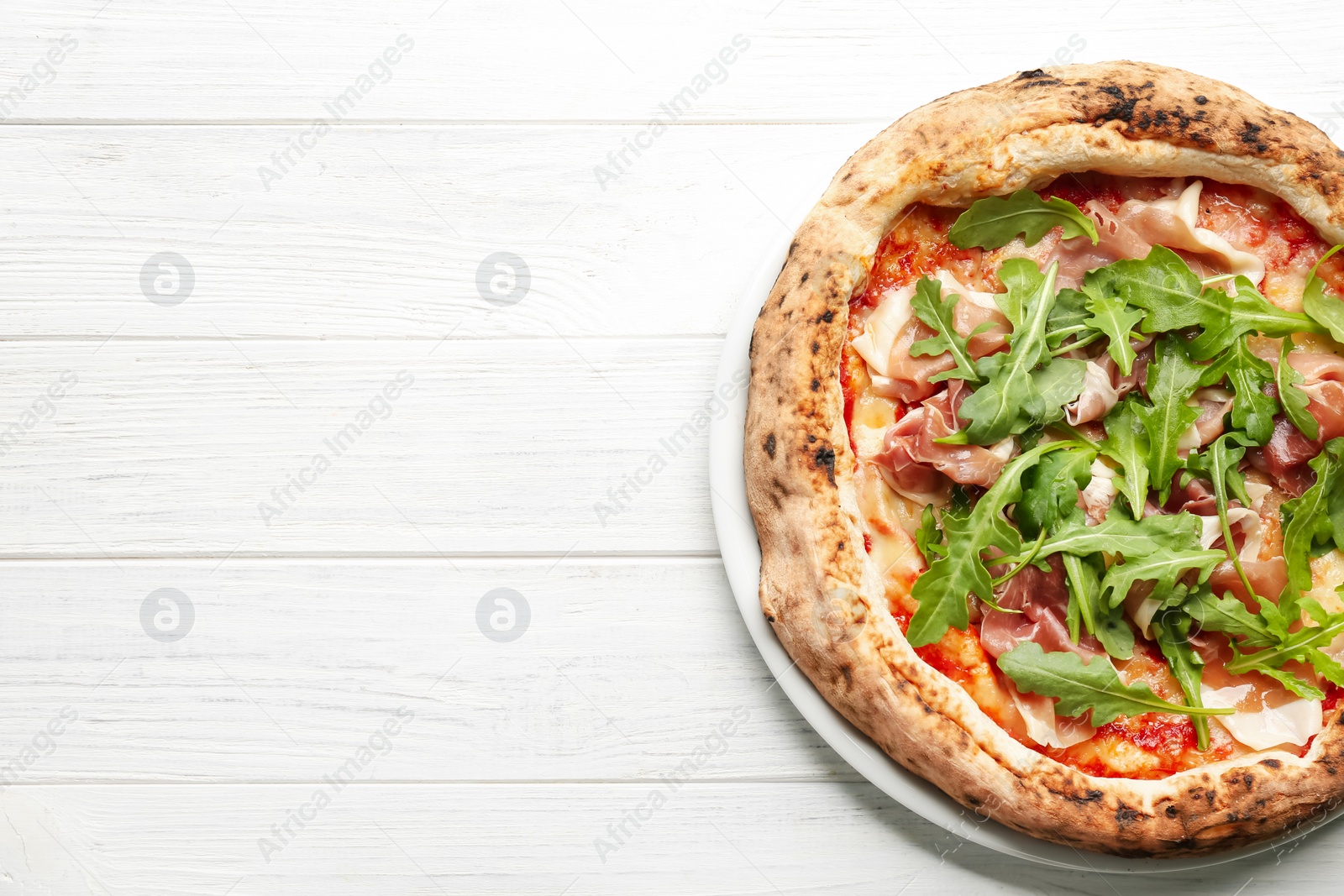 Tasty pizza with meat and arugula on white wooden table, top view. Space for text Photo of Tasty pizza with meat and arugula on white wooden table, top view. Space for text