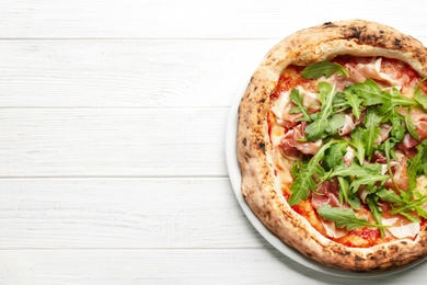 Tasty pizza with meat and arugula on white wooden table, top view. Space for text Photo of Tasty pizza with meat and arugula on white wooden table, top view. Space for text