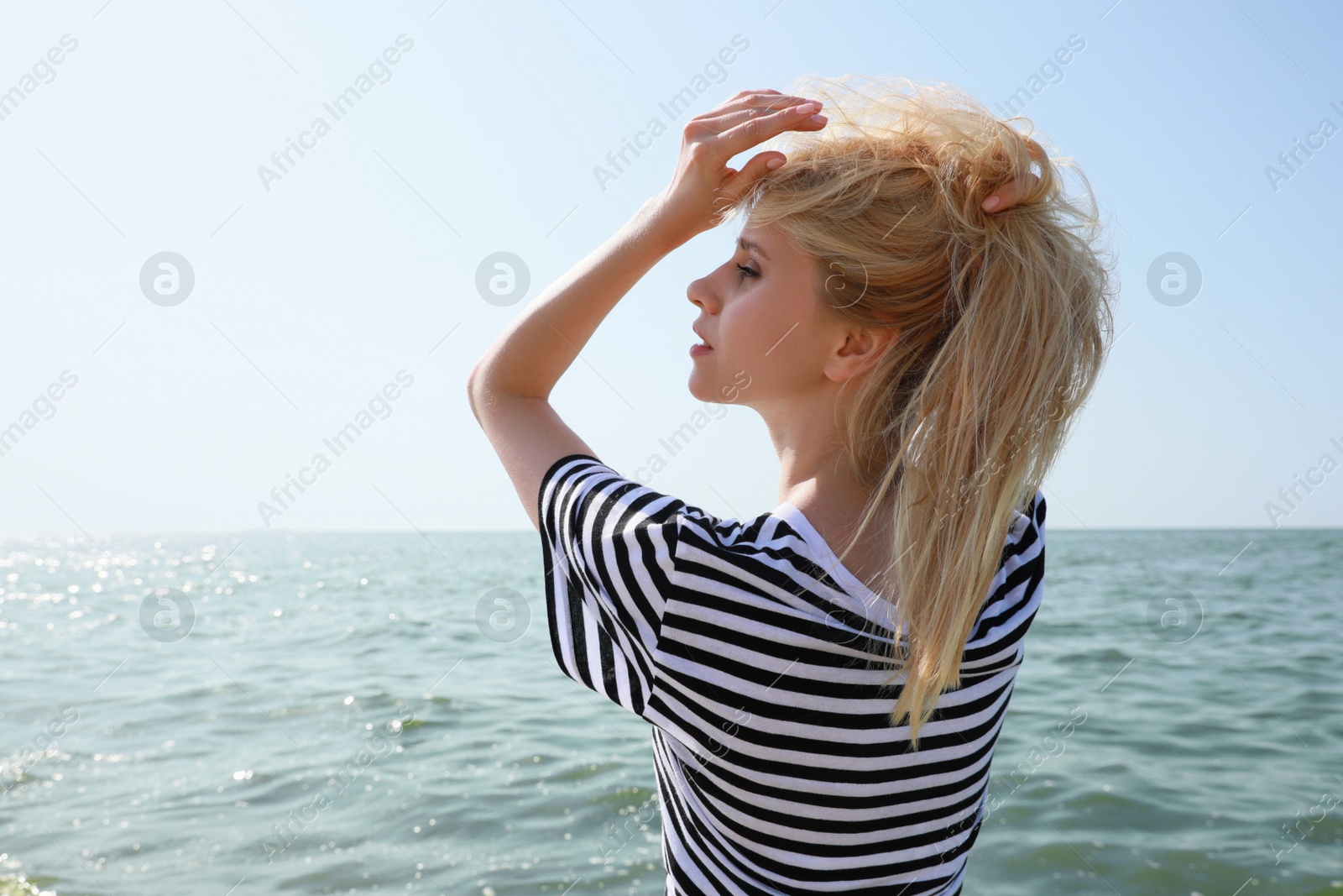 Beautiful young woman near sea on sunny day in summer Photo of Beautiful young woman near sea on sunny day in summer