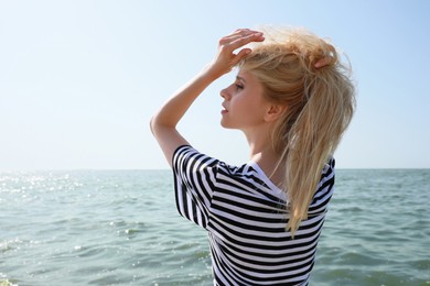 Beautiful young woman near sea on sunny day in summer Photo of Beautiful young woman near sea on sunny day in summer