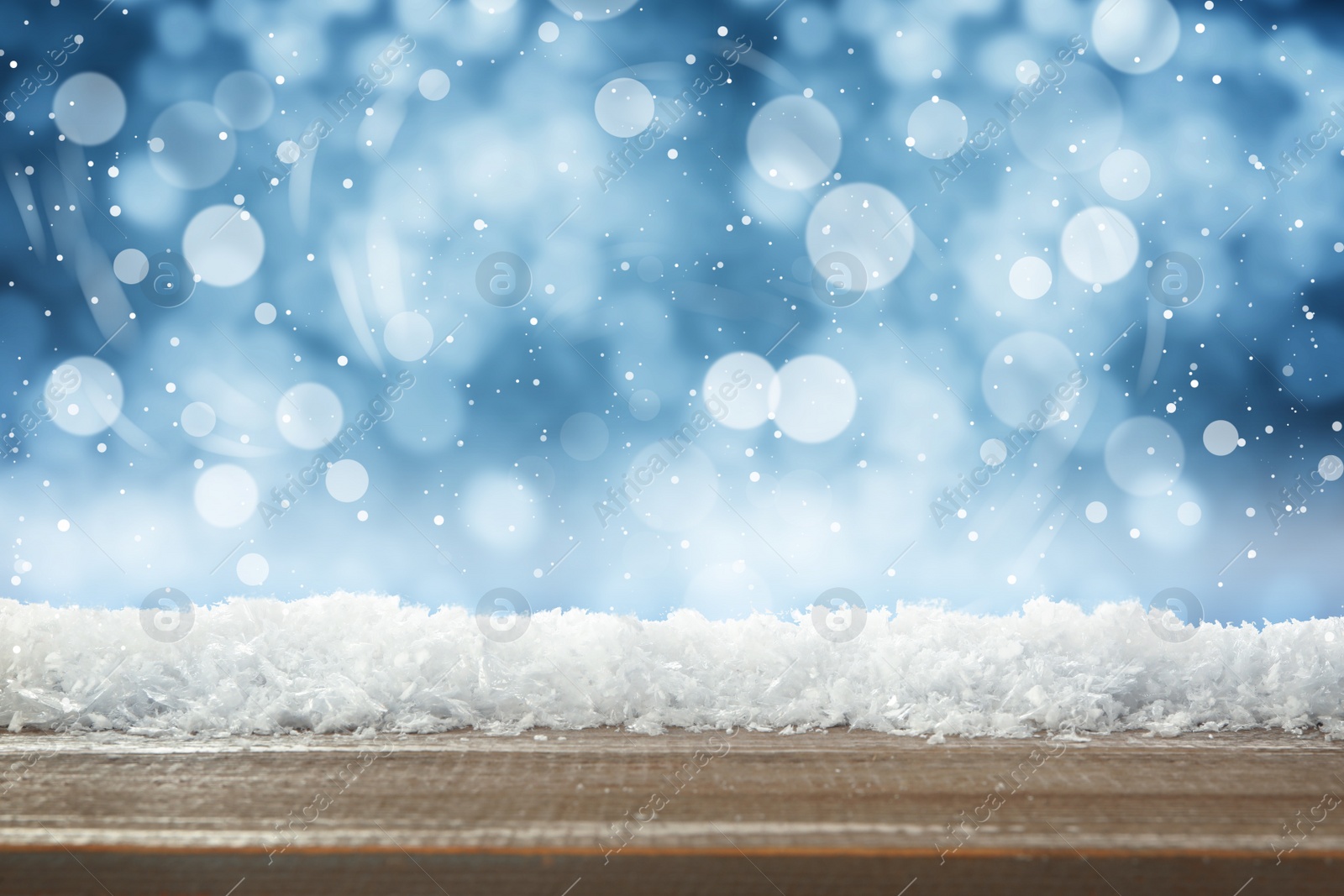 Wooden surface with snow against blue background, bokeh effect Image of Wooden surface with snow against blue background, bokeh effect