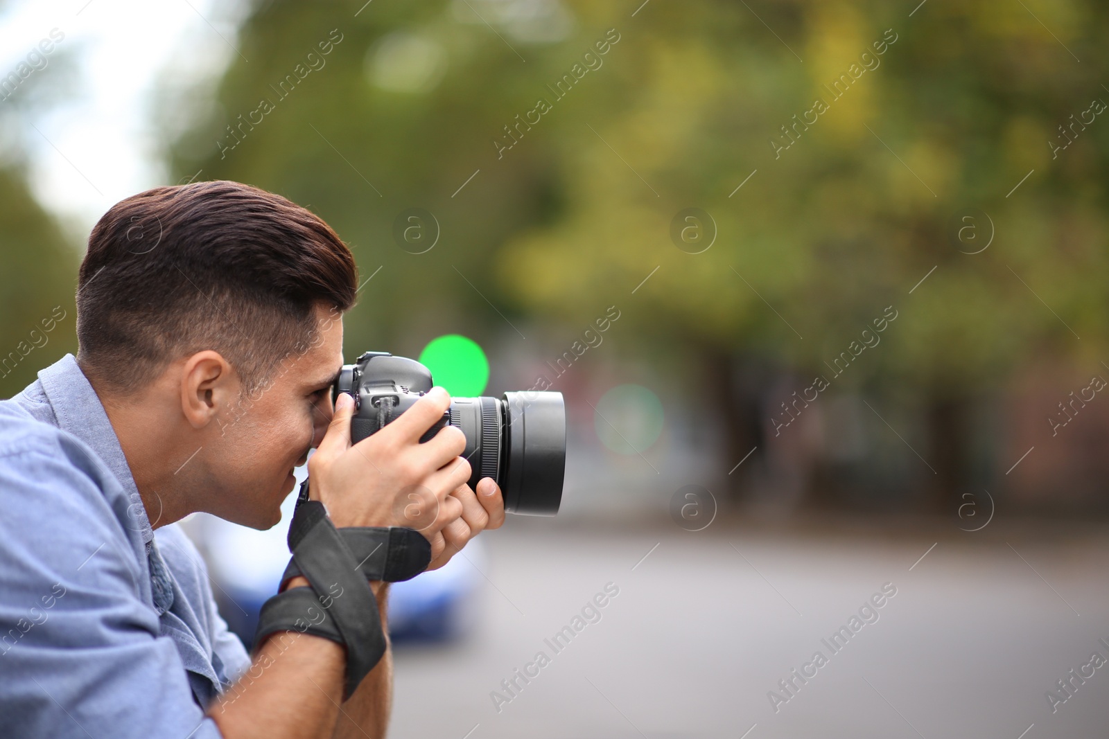 Photographer taking picture with professional camera on city street Photo of Photographer taking picture with professional camera on city street