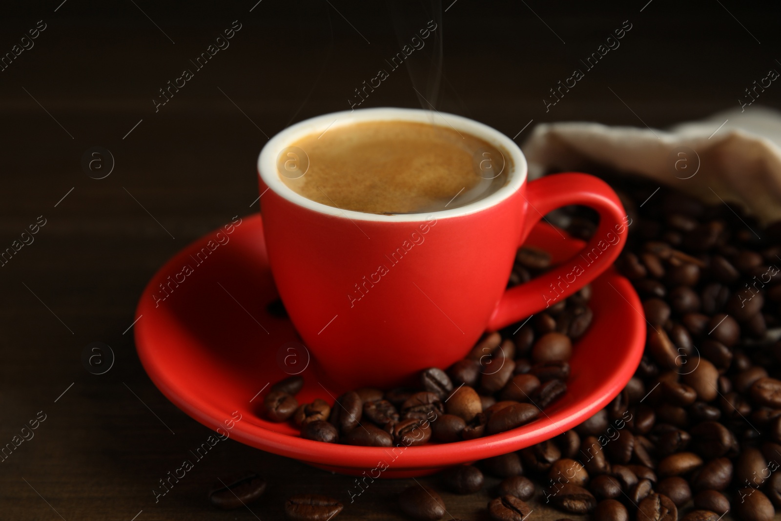 Cup of tasty coffee and beans on wooden table Photo of Cup of tasty coffee and beans on wooden table