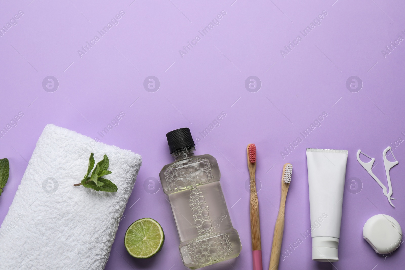 Flat lay composition with mouthwash and other oral hygiene products on violet background. Space for text Photo of Flat lay composition with mouthwash and other oral hygiene products on violet background. Space for text