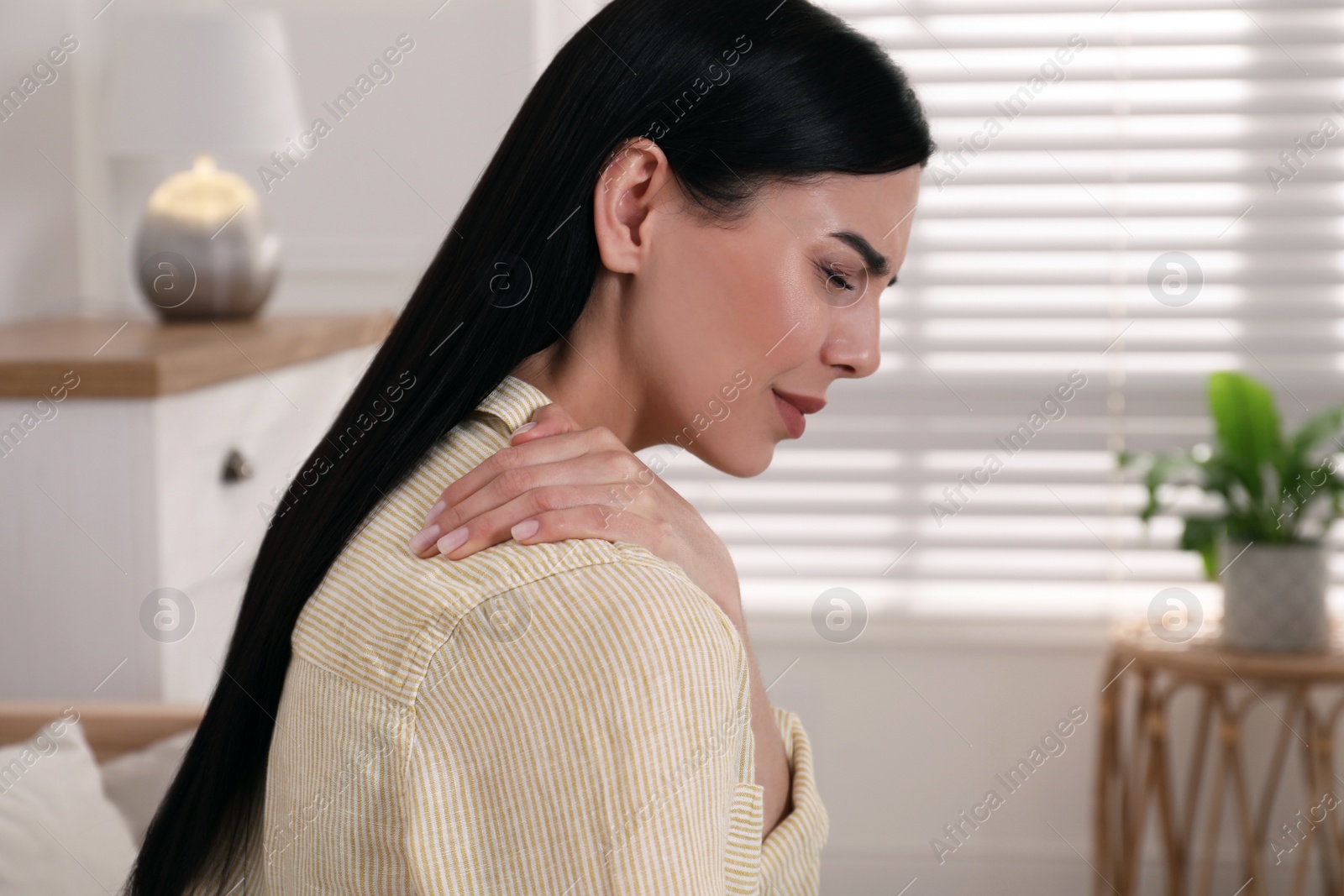 Woman suffering from shoulder pain at home Photo of Woman suffering from shoulder pain at home