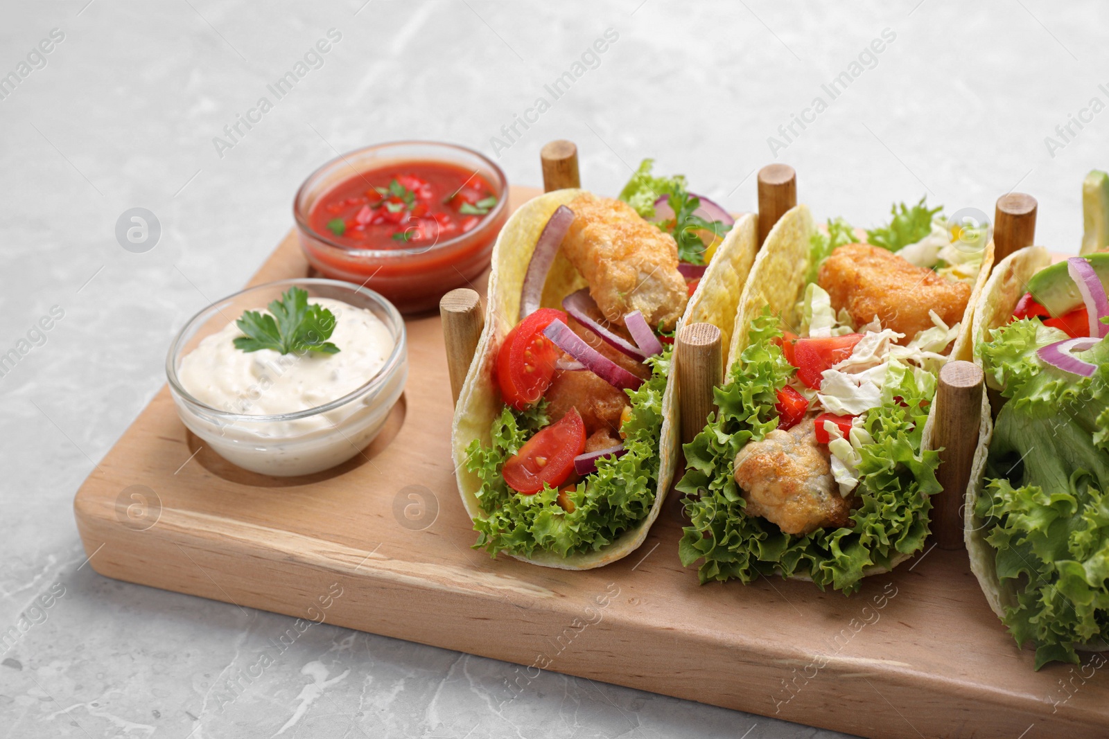 Delicious fish tacos served on grey marble table Photo of Delicious fish tacos served on grey marble table