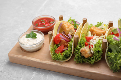 Delicious fish tacos served on grey marble table Photo of Delicious fish tacos served on grey marble table