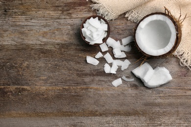 Composition with fresh coconut flakes on wooden background Photo of Composition with fresh coconut flakes on wooden background