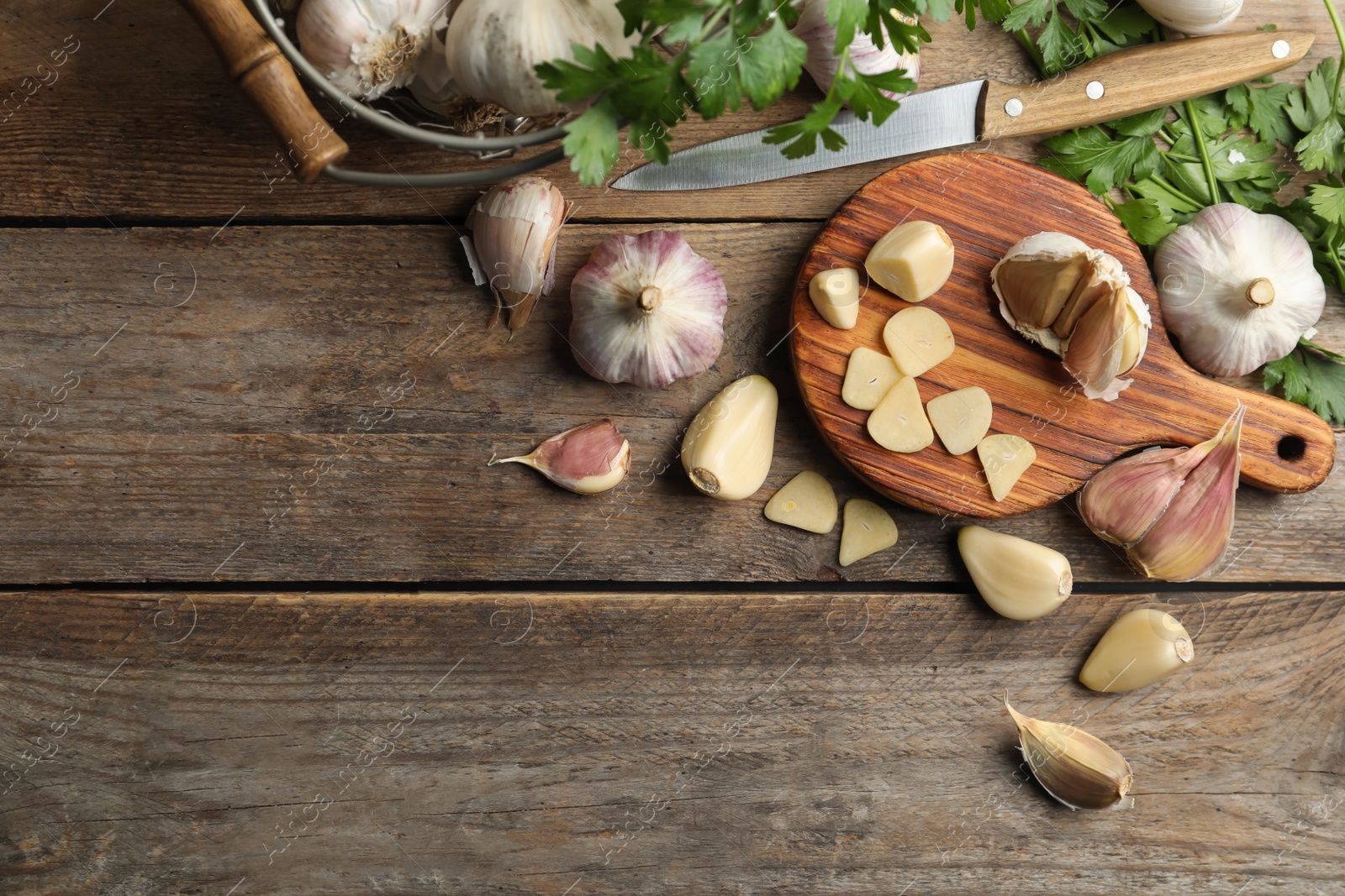 Flat lay composition with fresh sliced and whole garlic on wooden table, space for text. Organic product Photo of Flat lay composition with fresh sliced and whole garlic on wooden table, space for text. Organic product