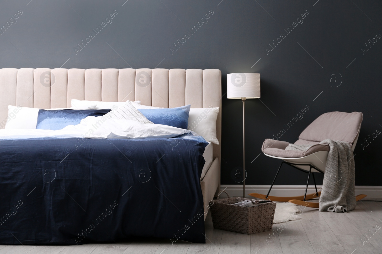 Comfortable bed with pillows and soft blanket in room. Stylish interior design Photo of Comfortable bed with pillows and soft blanket in room. Stylish interior design