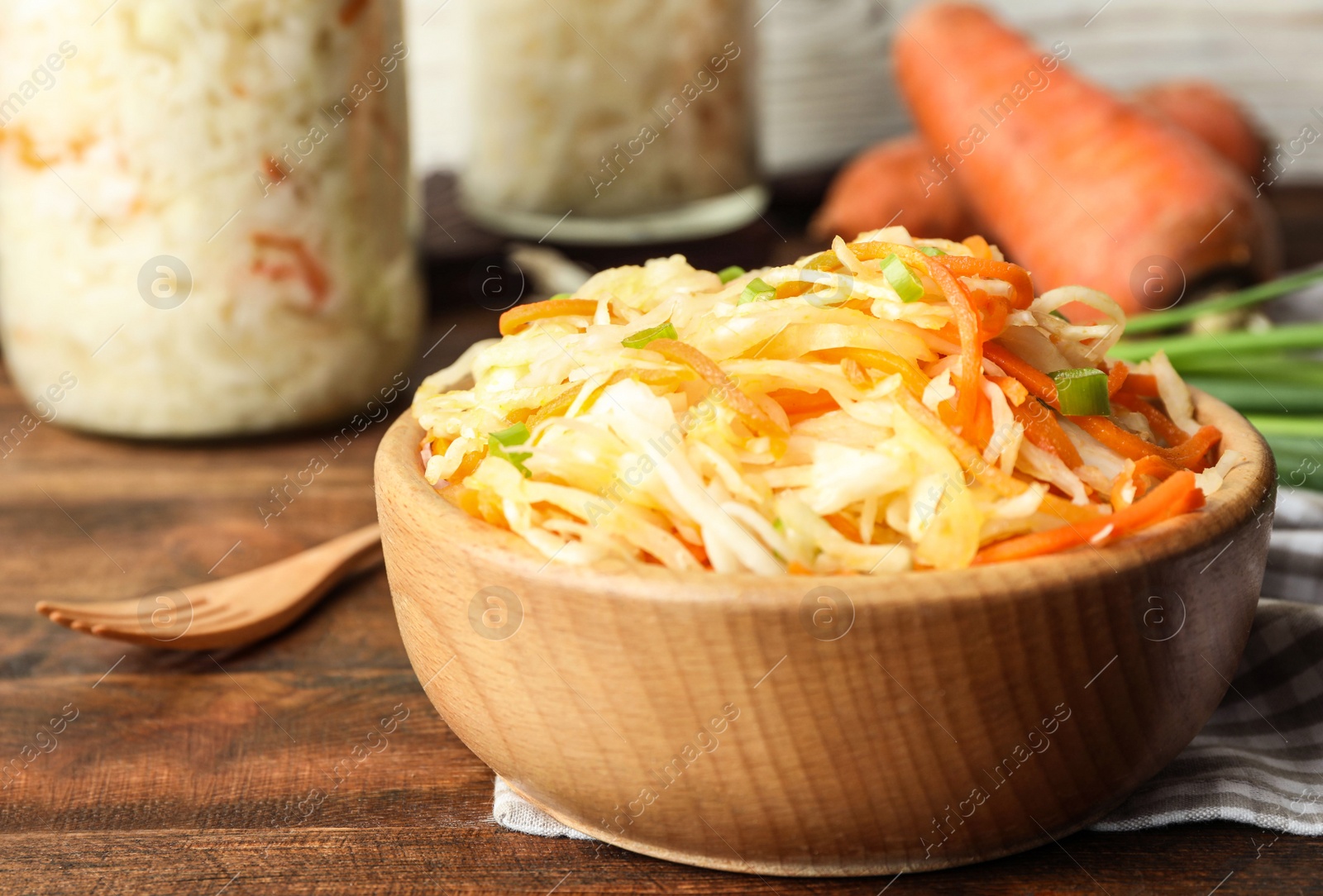 Tasty fermented cabbage on wooden table, closeup Photo of Tasty fermented cabbage on wooden table, closeup